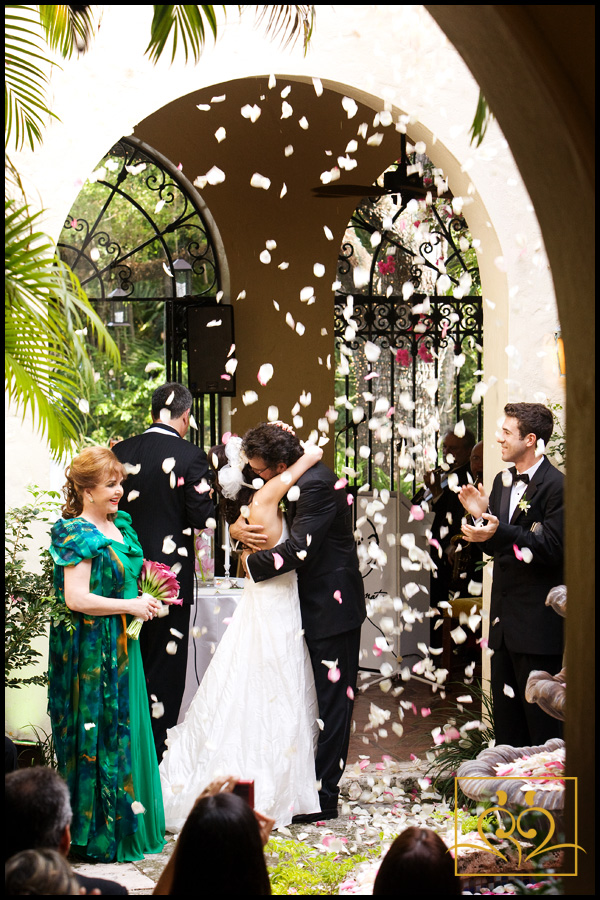 Rose petals float down onto the happy couple as they have their first kiss.
